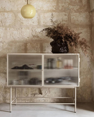 Vitrina completa contra un muro de piedra con utensilios dentro.