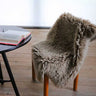 Alfombra Woolly gris colocada junto a una cama